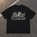 The Black Champions TBC tee – flat lay